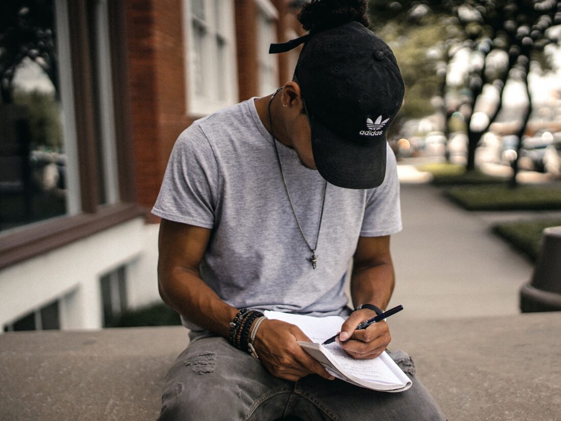 Ein Junge schreibt etwas auf Papier